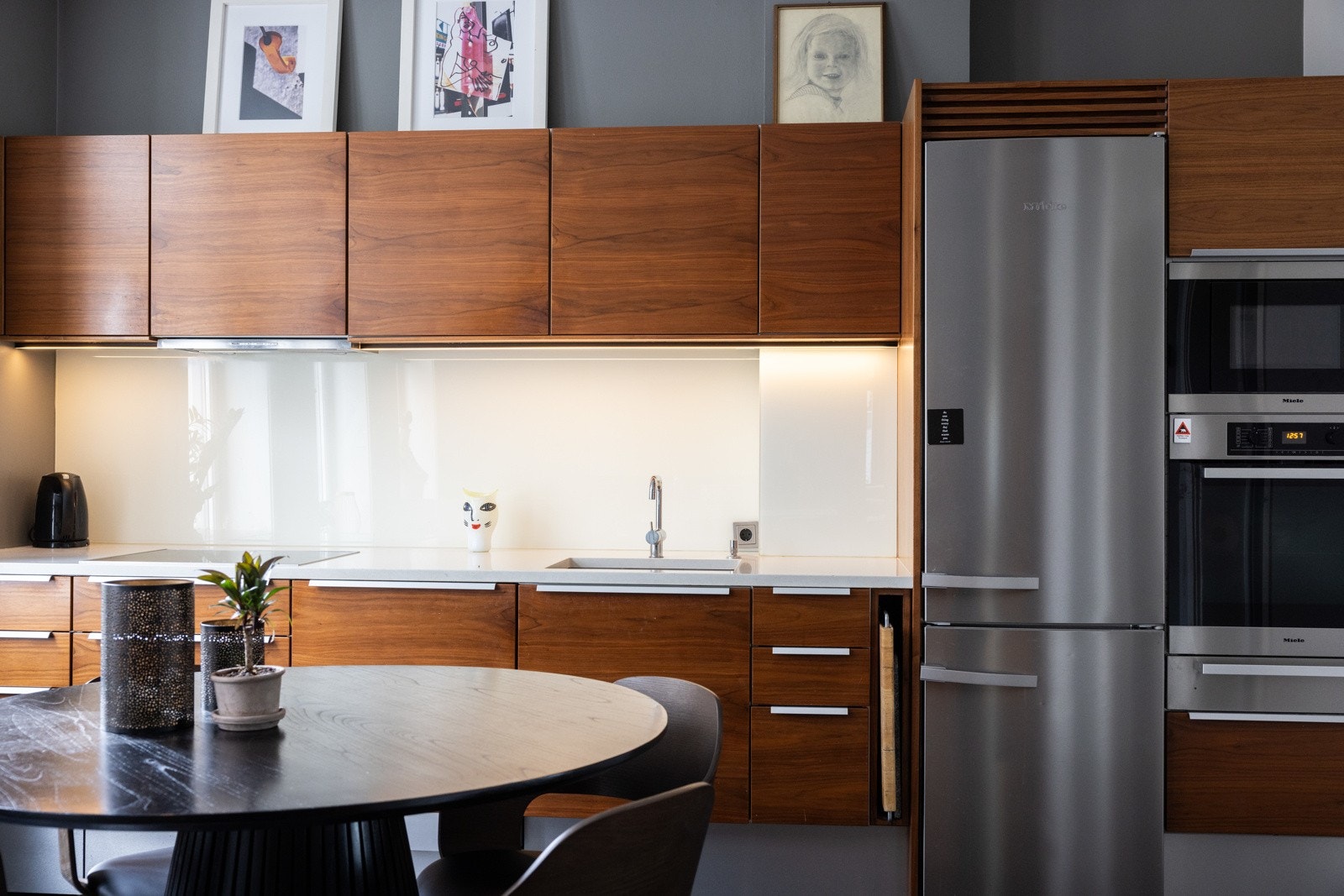 Her finner du stekeovn og micro i høyskap, oppvaskmaskin, koketopp, kjøleskap/frys og vinskap, alt sømløst integrert for en ren og moderne stil. Galleribilde