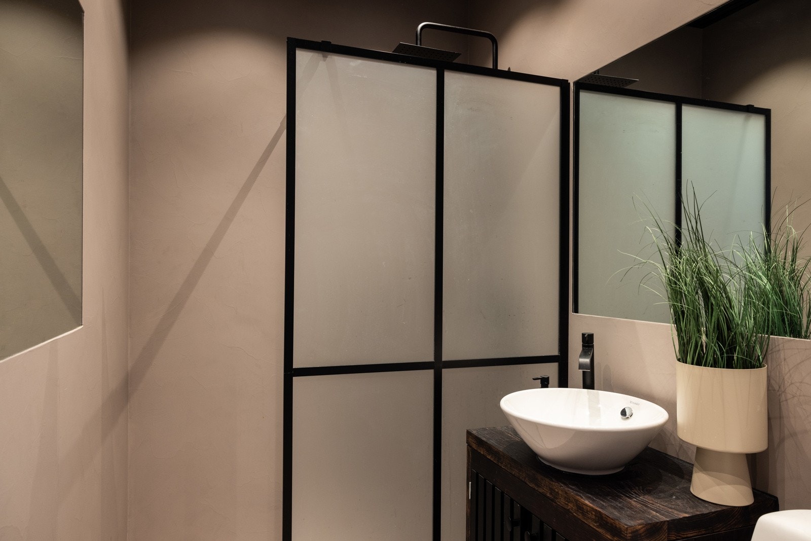 Badet har gulvmontert klosett, håndvask med speil og innredning, en dusjnisje med glassvegg og opplegg for vaskemaskin. Galleribilde