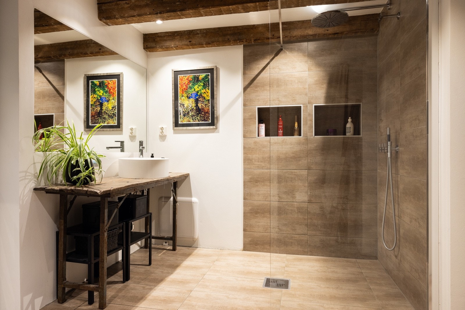 Det er utstyrt med en romslig dusjnisje og en håndvask med benk og speil, og har direkte tilgang til soverommet. Galleribilde