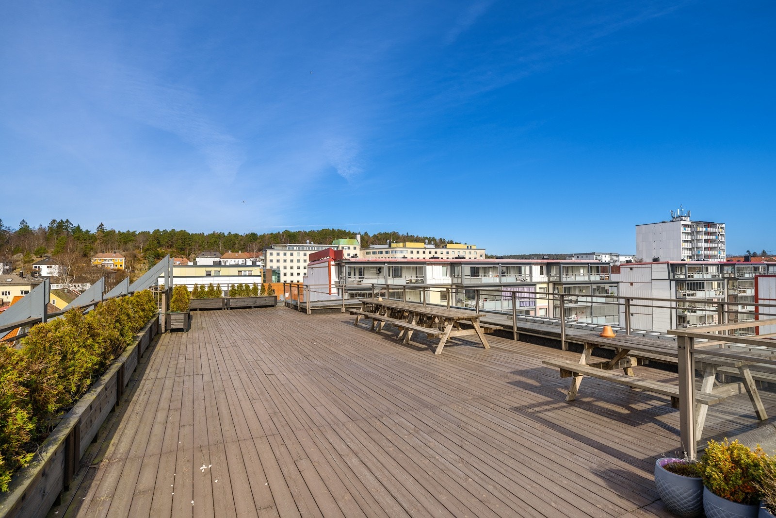 Stor felles takterrasse med flere sittegrupper og fantastisk utsikt over byen og sjøen med sol fra morgen til sen kveld. Galleribilde