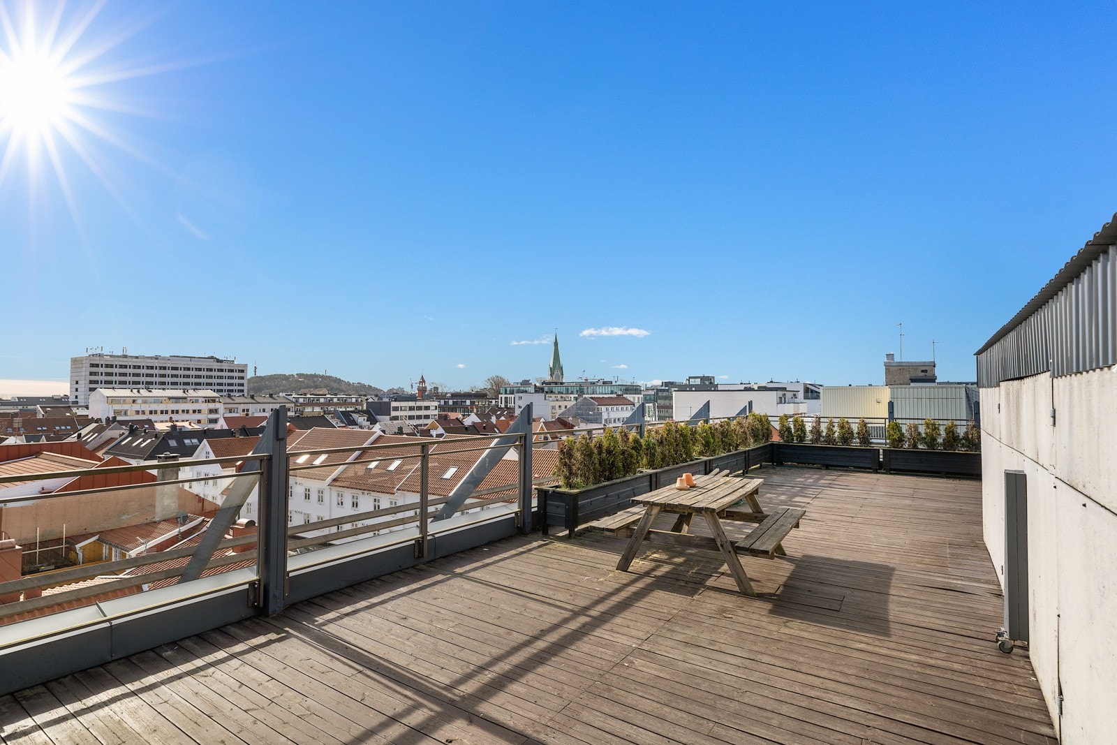 Stor felles takterrasse med flere sittegrupper og fantastisk utsikt over byen og sjøen med sol fra morgen til sen kveld. Galleribilde
