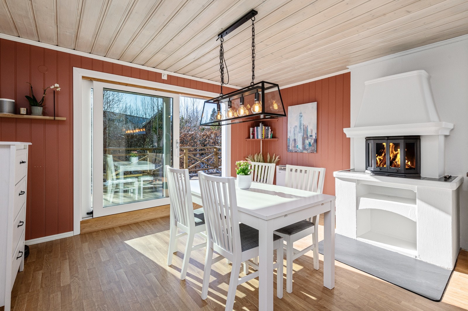 Stort og luftig kjøkken med stor skyvdør som slipper inn mye lys. Murt peis for koselige stunder på kjøkkenet Galleribilde