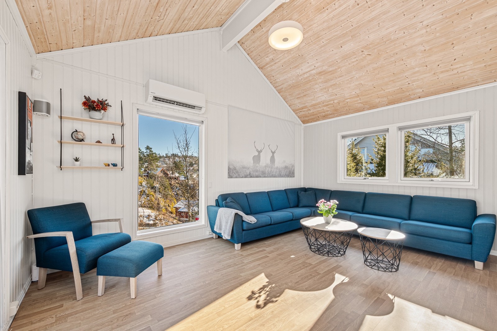 Flott stue med stor takhøyde og vinduer som går helt ned til gulvet på to sider - mye lys og luft Galleribilde