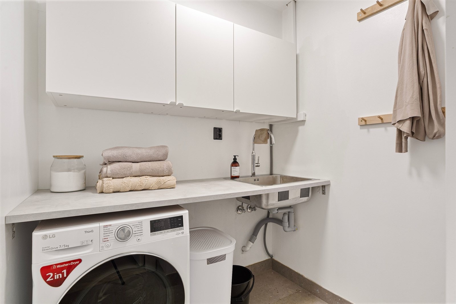 Vaskerommet er på ca. 3,5 kvm og praktisk innredet med benkeplate, veggskap, stålvask og opplegg for vaskemaskin og tørketrommel. Galleribilde