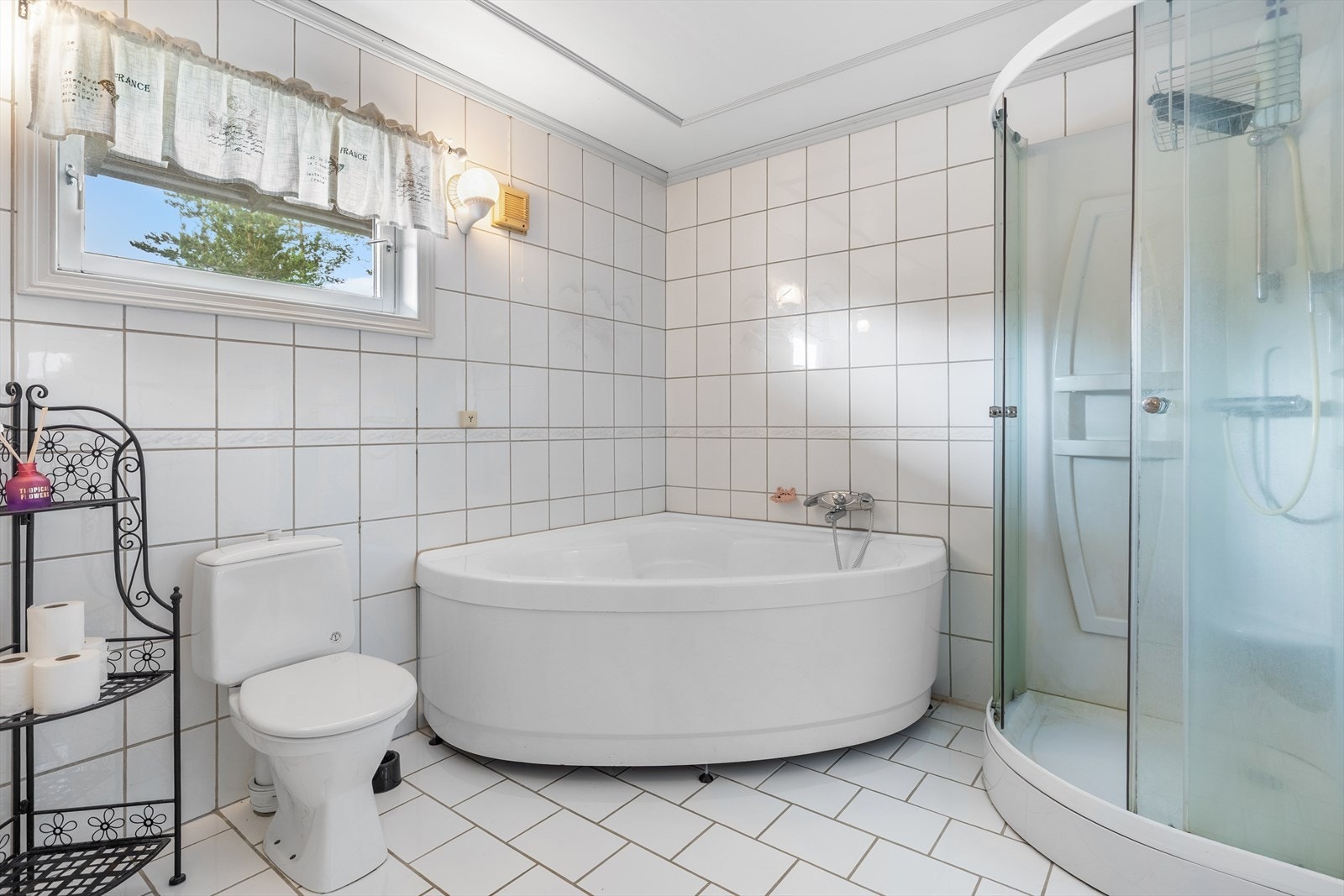 Badet er innredet med servant, toalett, dusjkabinett og badekar Galleribilde