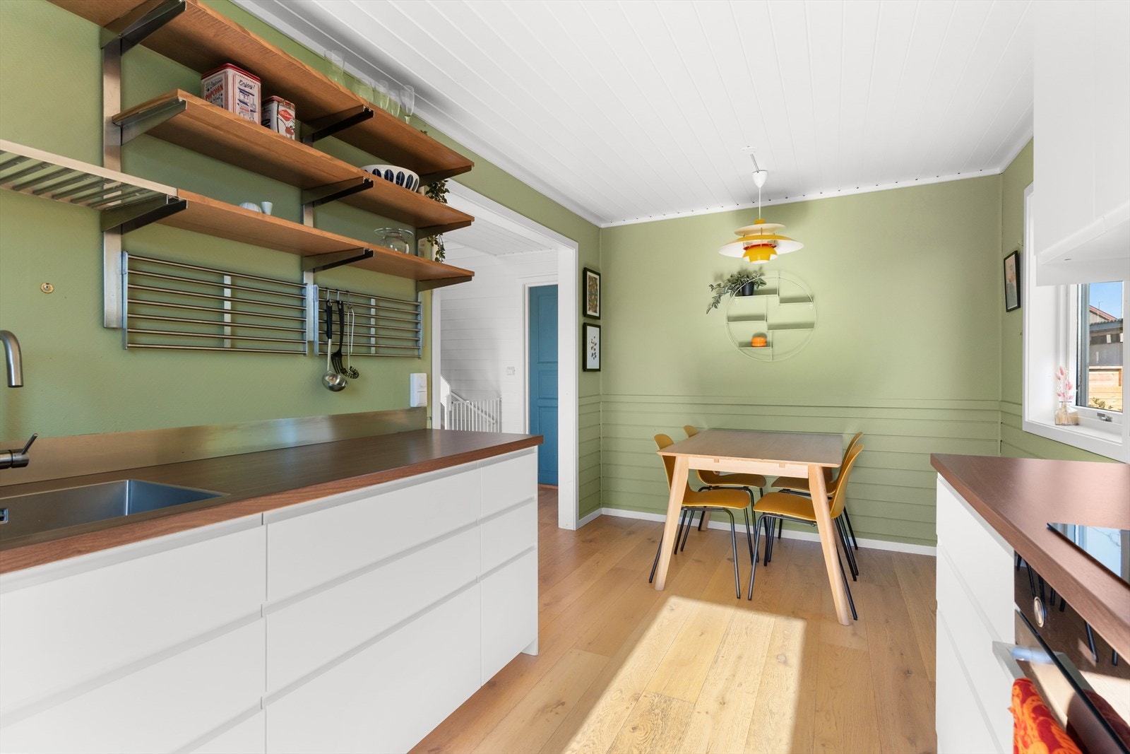 Også kjøkkenet er blitt malt i en svært trivelig farge - grønntonen står fint til den hvite innredningen og tredetaljene. Galleribilde