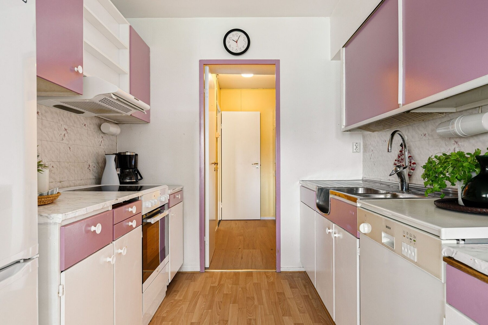 Kjøkkeninnredning bestående av over- og underskap med malte fronter og skrog. Benkeplaten er laminert med nedsenket vask. Galleribilde