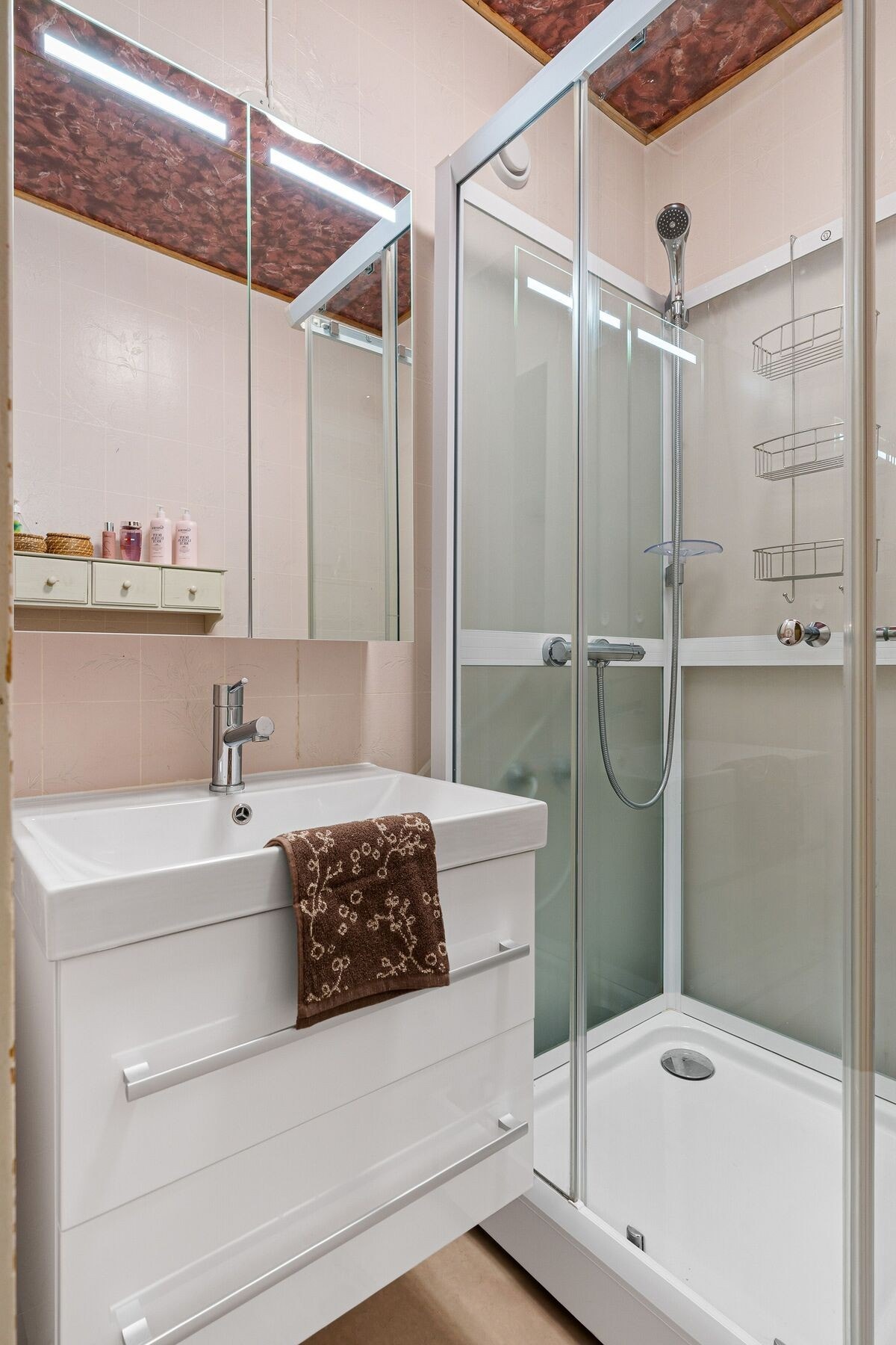 Lyst baderom med våtromsbelegg på gulv og våtromstapet på vegg. Galleribilde