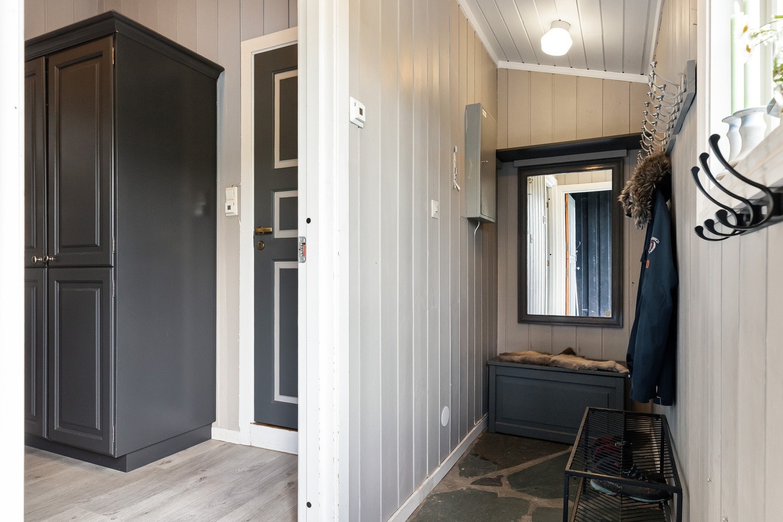 Entré med plass til å henge fra seg yttertøy og sko. Skiferfliser på gulv med varmekabler. Galleribilde