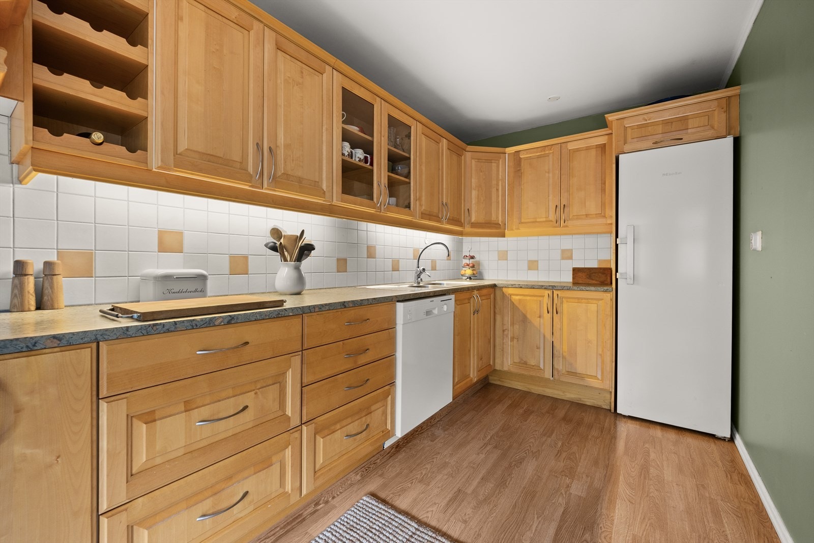 Kjøkkenfrontene er profilerte, og benkeplaten er i laminat med nedfelt vask. Galleribilde