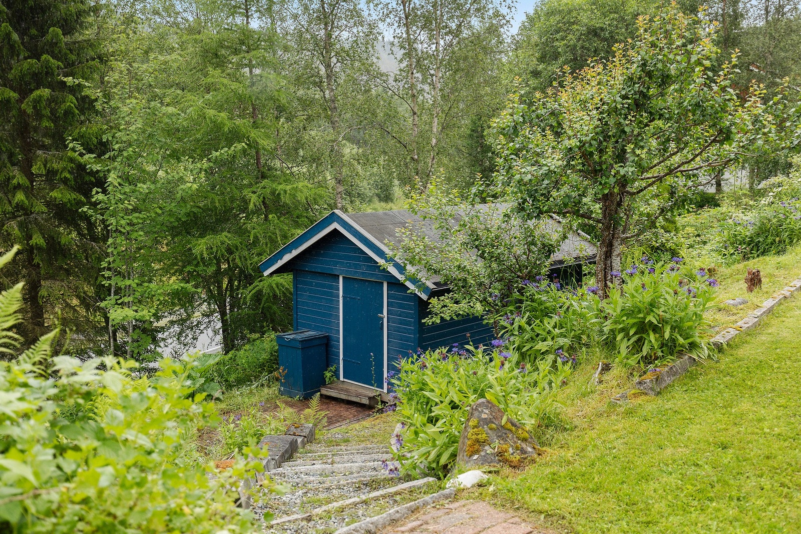 Det medfølger både utebod og drivhus på tomten. Tilrettelagt for deg som er glad i hagelivet. Galleribilde