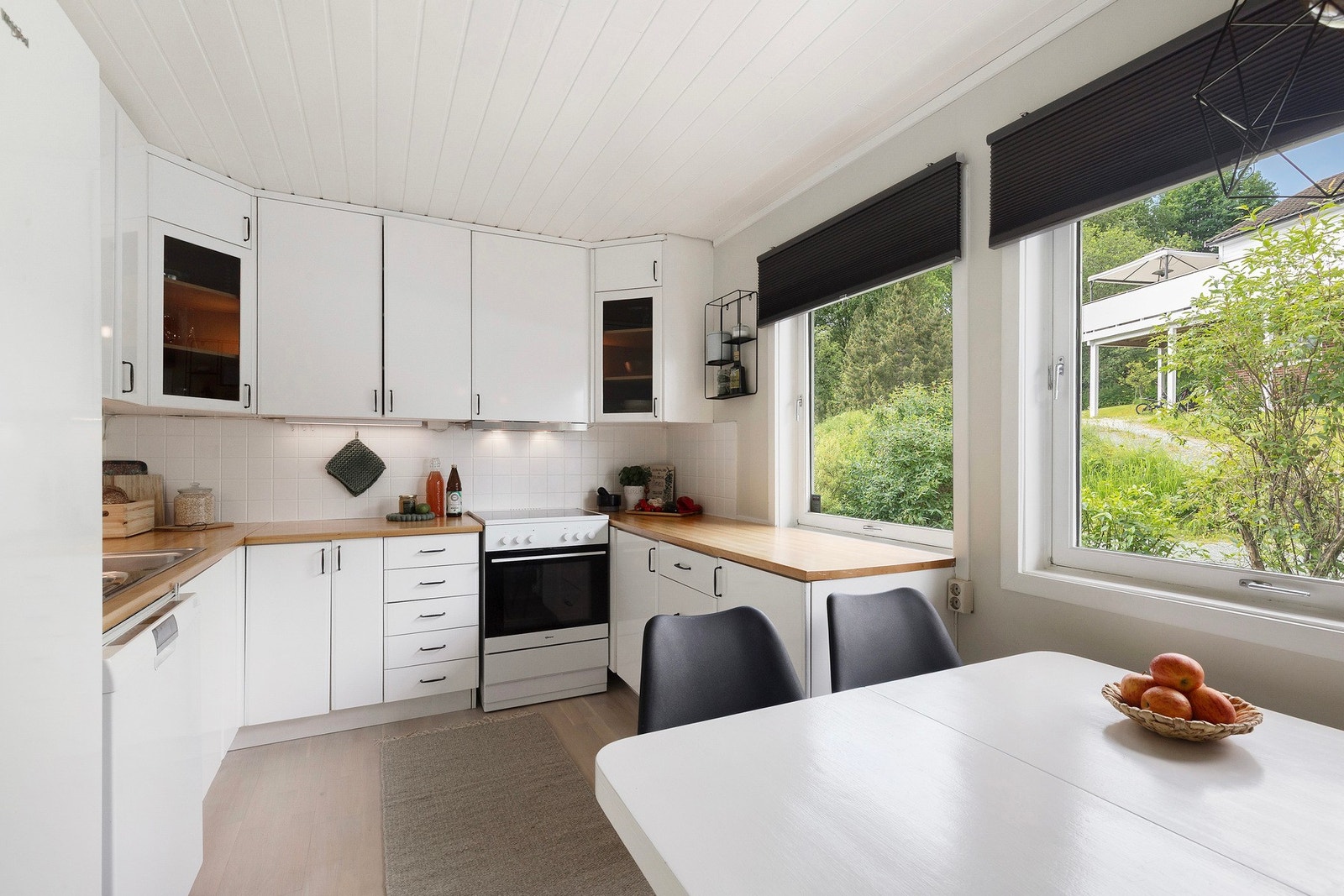 Romslig kjøkken med god skapplass og fine arbeidsflater for kokken. Galleribilde