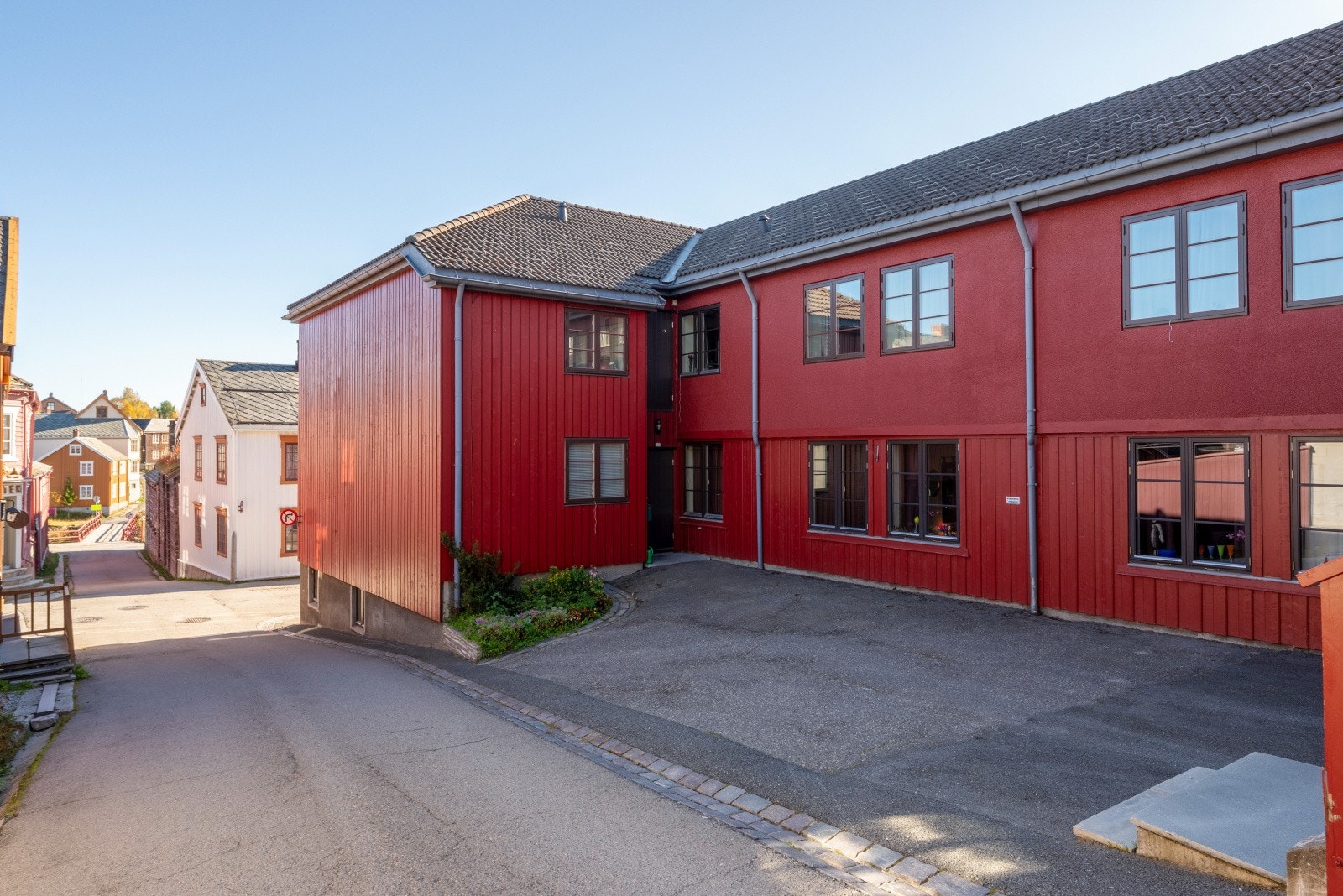 Leiligheten har en svært sentral plassering midt i hjertet av Røros sentrum. Det er inngang til bygget både fra Rau-Veta og fra Bergmannsgata. Her sett fra Rau-Veta. Galleribilde
