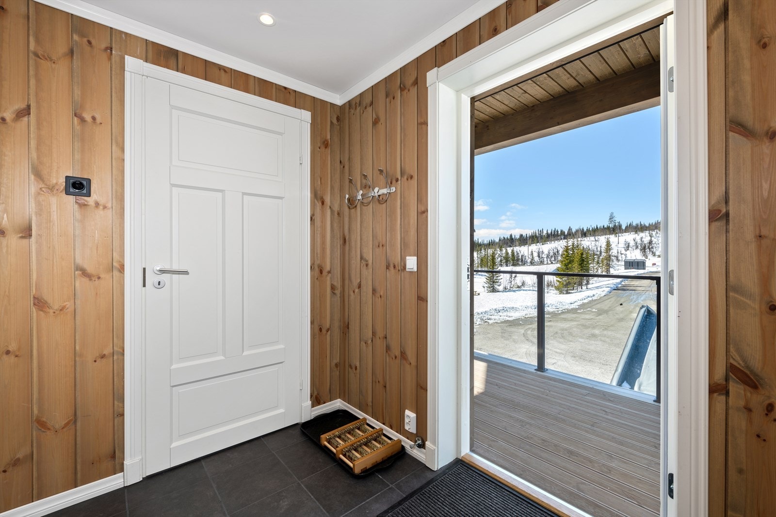 Romslig, flislagt entré med plass til å sette fra seg vått skotøy og yttertøy. Varmekabler i gulv. Bildet er fra tilsvarende leilighet, bare speilvendt. Galleribilde