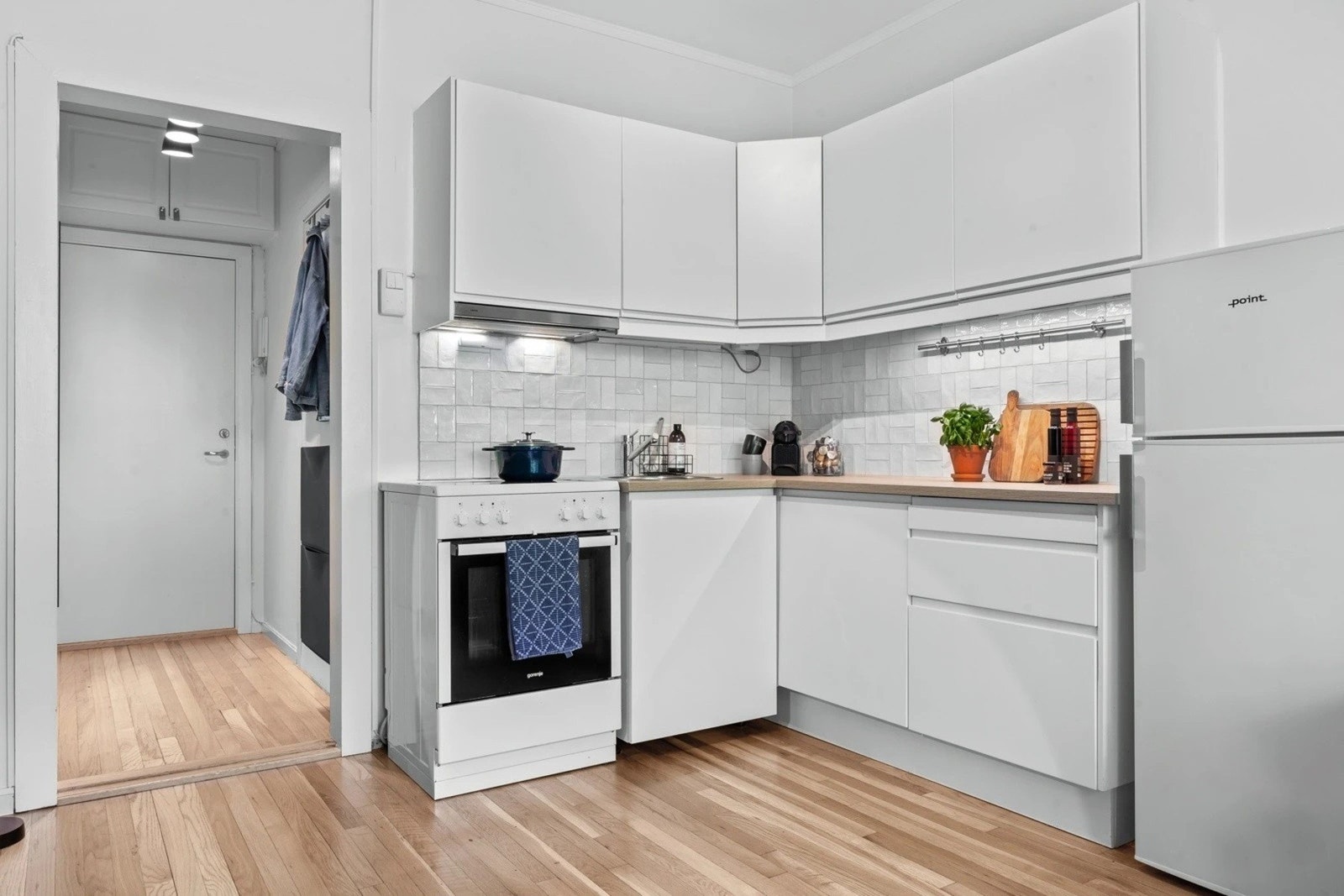 Kjøkkeninnredning med glatte fronter som gir et rent og tidløst uttrykk samt rikelig med oppbevaringsplass. Galleribilde