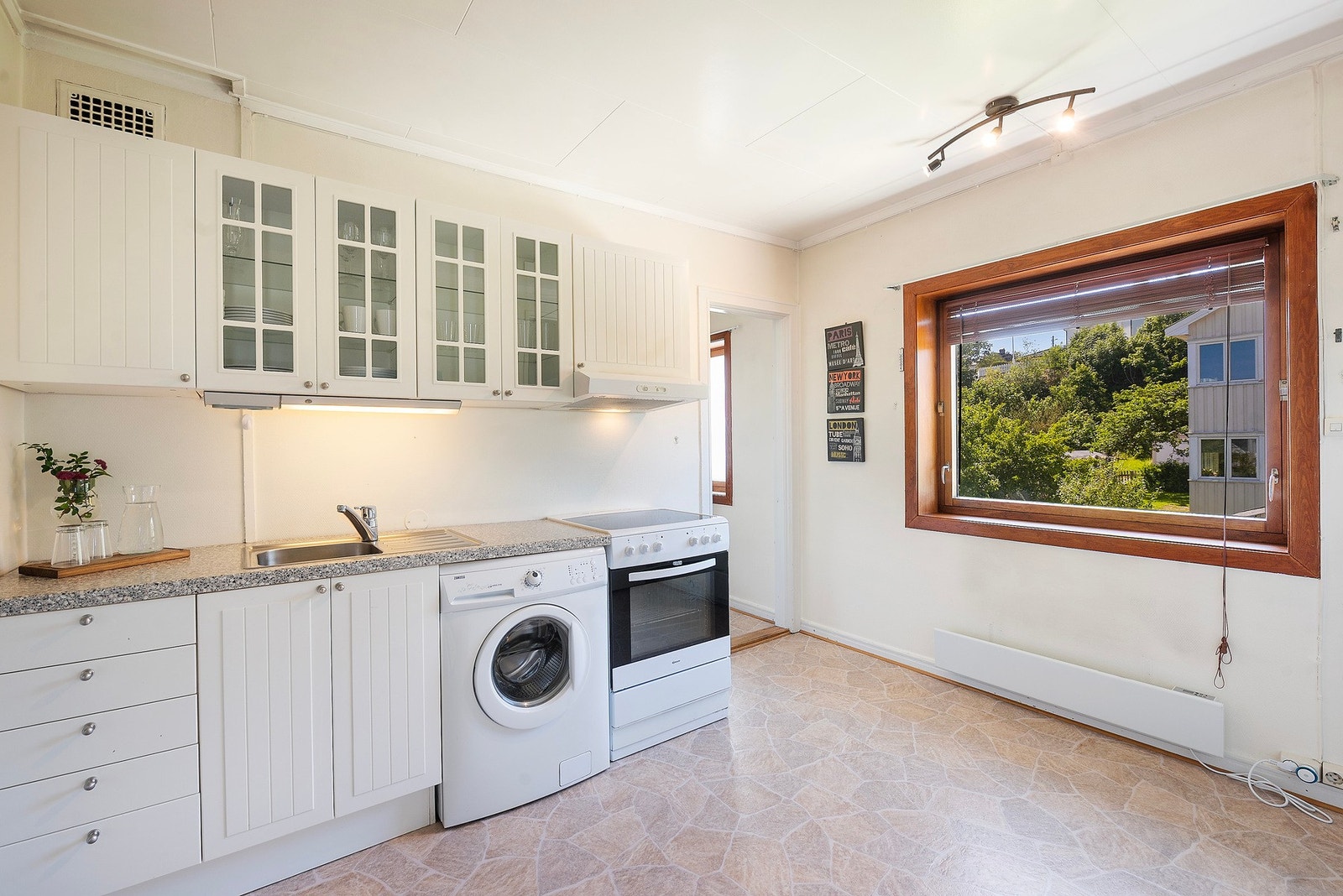 Kjøkkenet er innredet med profilerte fronter og laminat benkeplate - det er avtalt at oppvaskmaskin installeres og vaskemaskin flyttes ned til vaskerom. Galleribilde