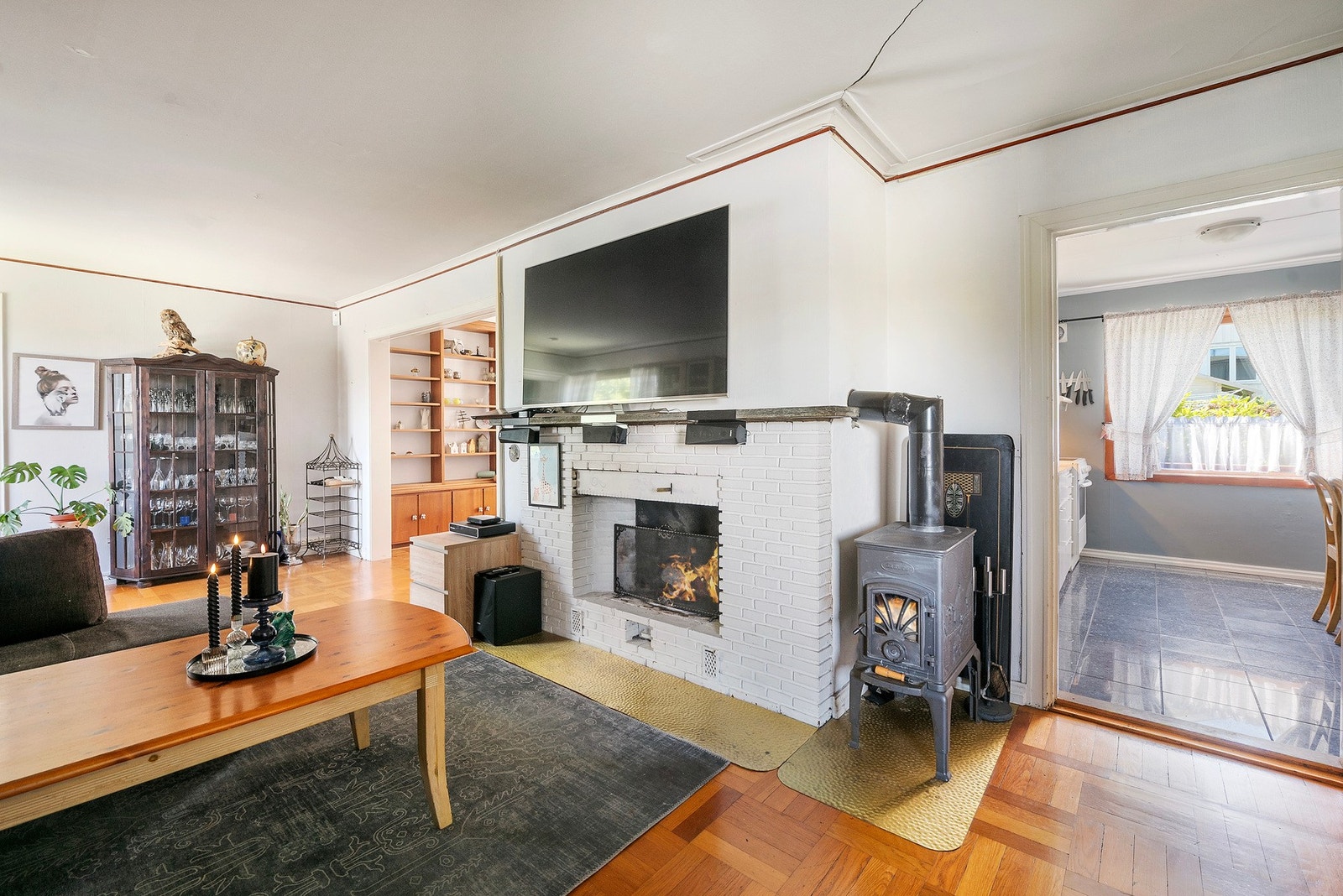 Åpen peis og peisovn med glassdør i stuen Galleribilde