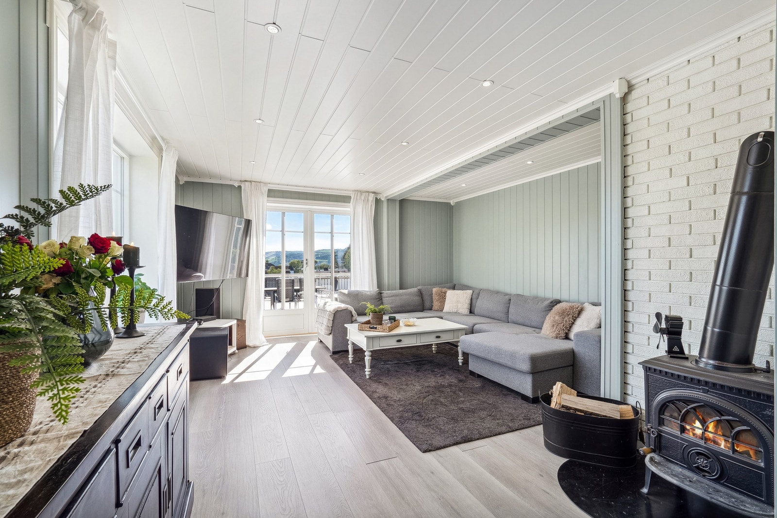 Delikat stue med sofagruppe og peisovn som gir en god og lun atmosfære Galleribilde