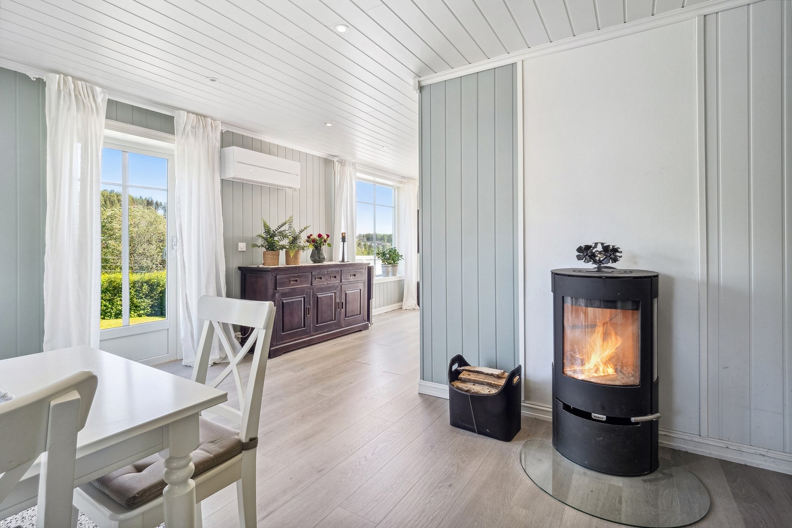Detaljer fra spisestue med nyere rentbrennende peisovn, også her er det egen utgang. Galleribilde