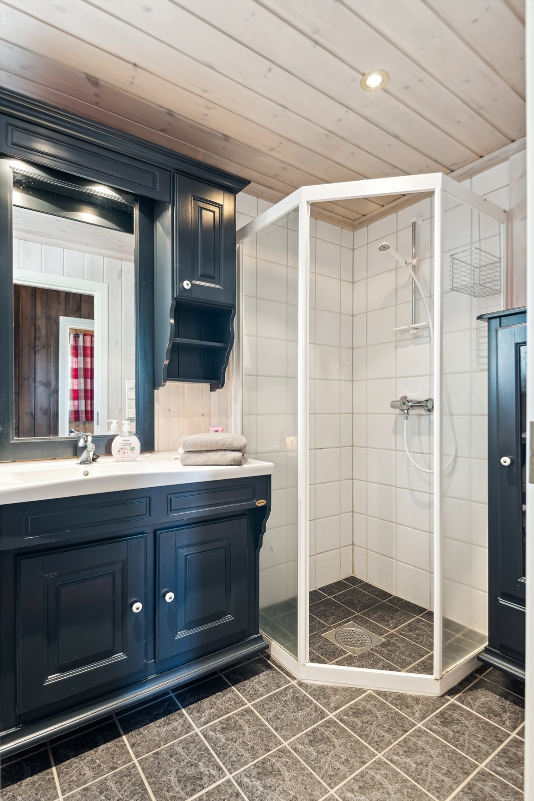 Dusjkabinett og servant med underskap gir et praktisk og funksjonelt baderom. Galleribilde