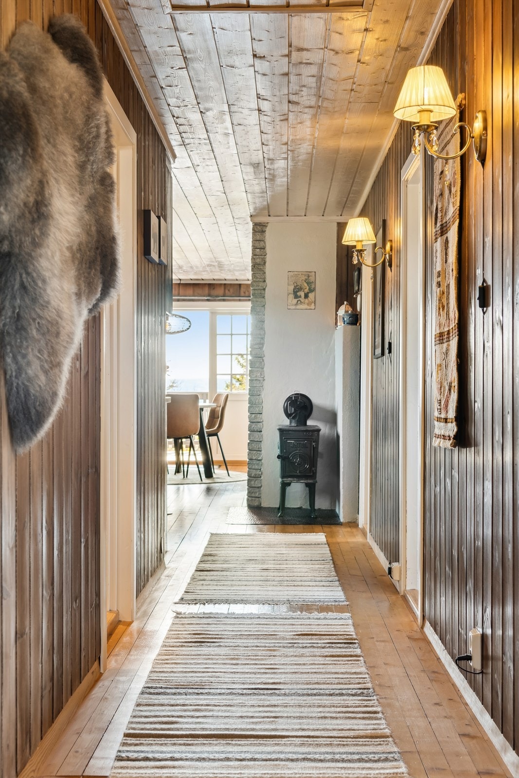 Mørkebeisede, panelkledde vegger binder hyttas rom sammen på en lun måte. Galleribilde