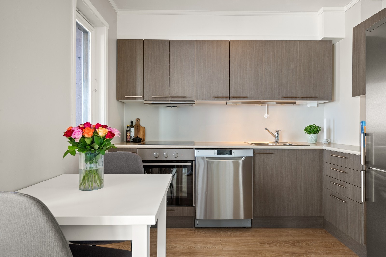 Stilig kjøkkeninnredning fra 2015 med integrert komfyr, platetopp, oppvaskmaskin og kjøl-/fryseskap Galleribilde