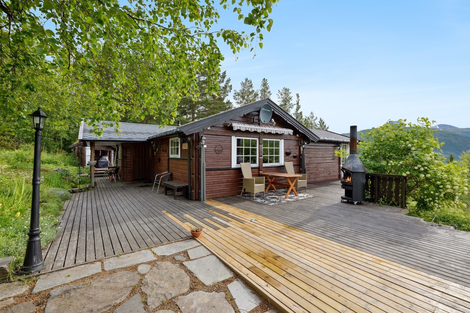 Terrassen er utstyrt med markise, uttrekkbar levegg og utepeis på hjul Galleribilde