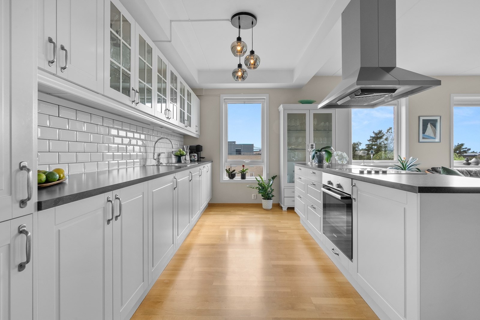 Denne løsningen gir både god oppbevaringsplass og en effektiv arbeidsflyt, perfekt for matlaging og sosialt samvær. Galleribilde