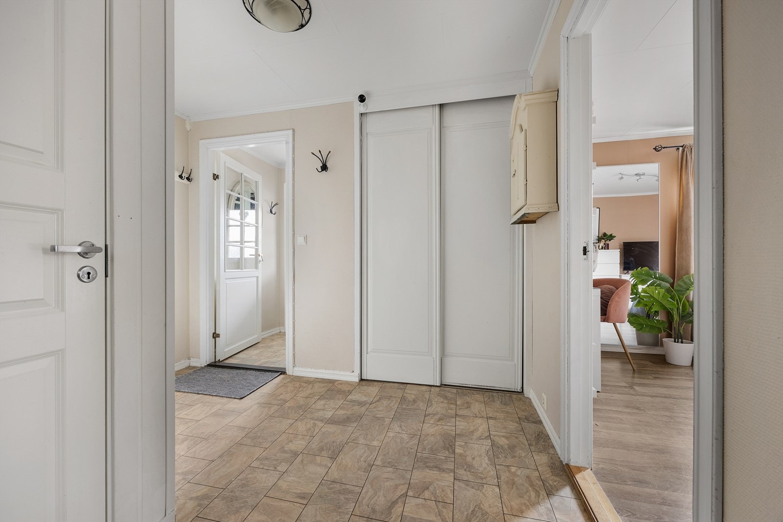 Videre fra entréenkommer man inn i en gang med en praktisk integrert skyvedørsgarderobe Galleribilde