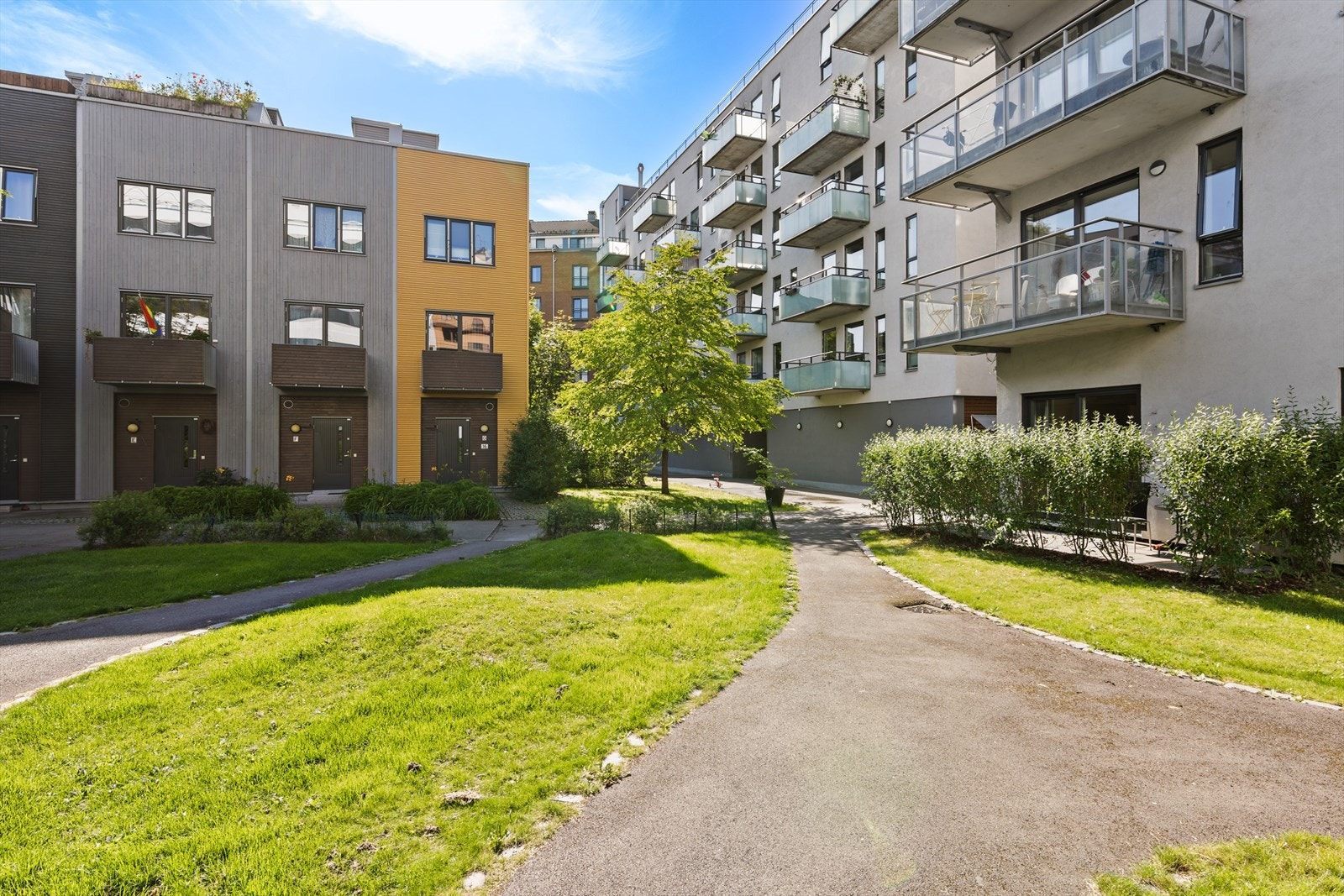 Innbydende gårdsrom med beplantning og pent opparbeidede internstier med rolig atmosfære midt i byen Galleribilde