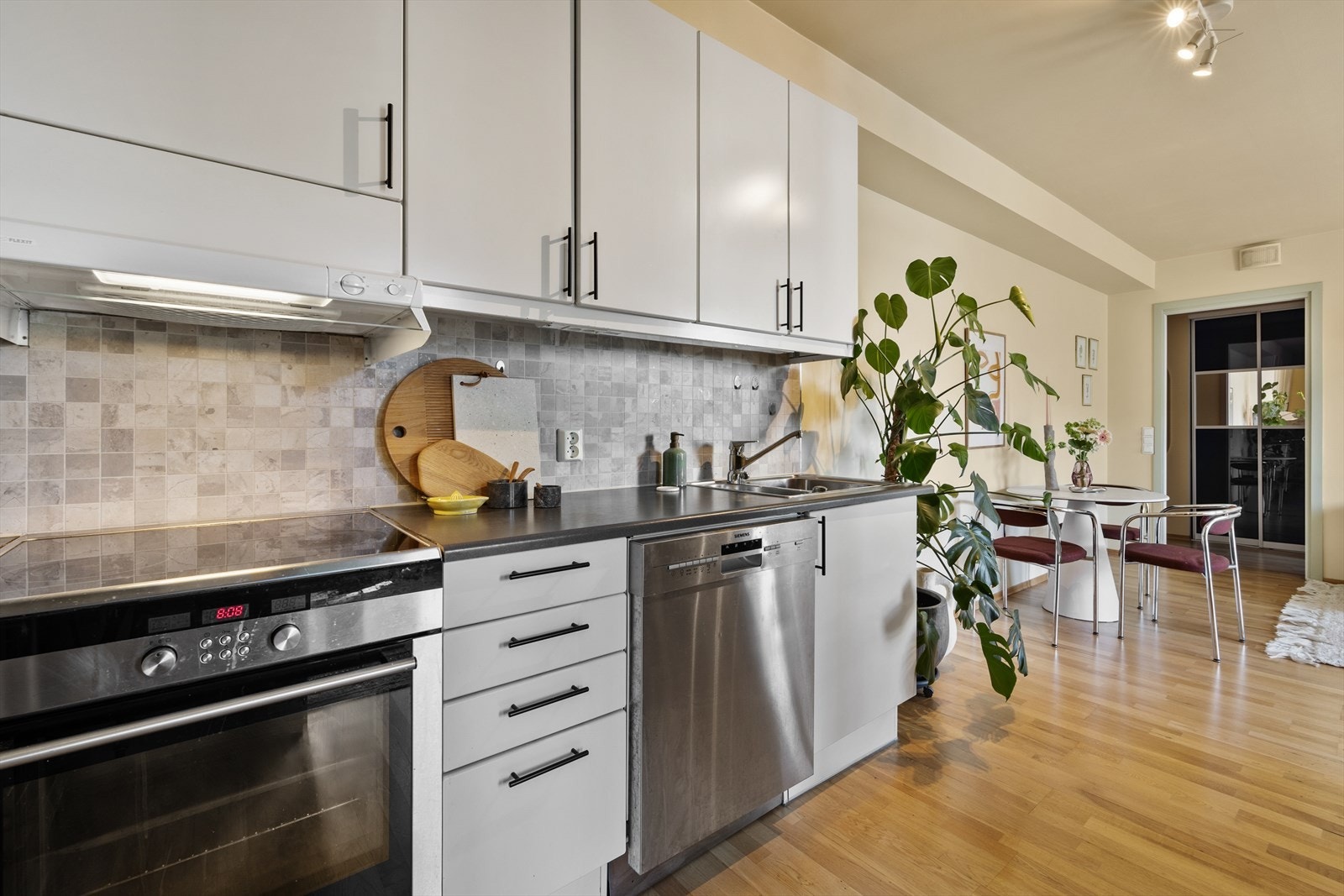 Kjøkkenets åpne løsning mot spiseplass gjør det enkelt å servere og sosialisere Galleribilde