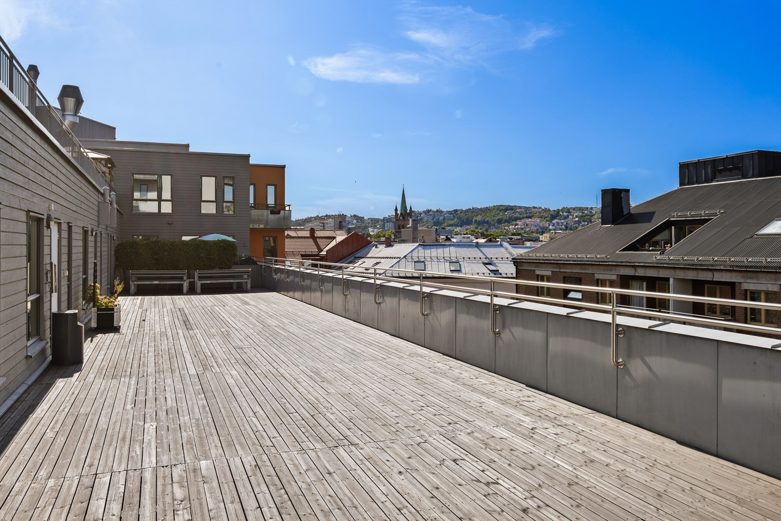 Romslig felles takterrasse med plankegulv - ideell for sosiale sammenkomster og avslapning under åpen himmel Galleribilde