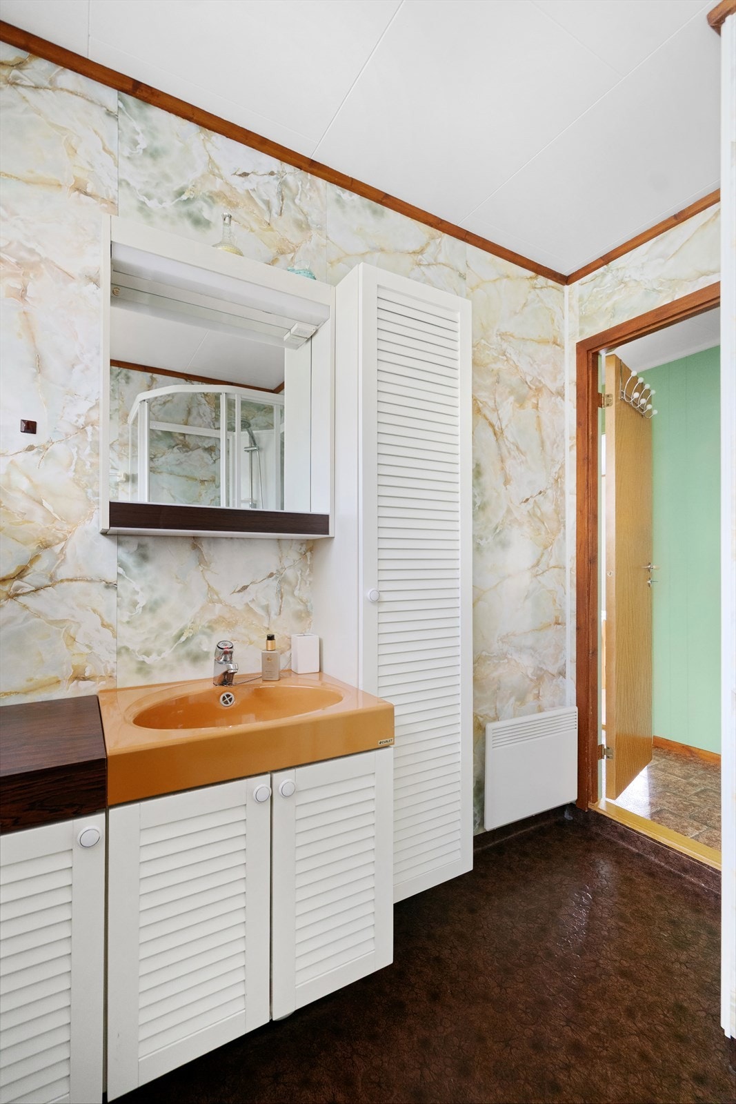 Badet har innredning med skap, vask, speil og lys, og dusjkabinett. Galleribilde