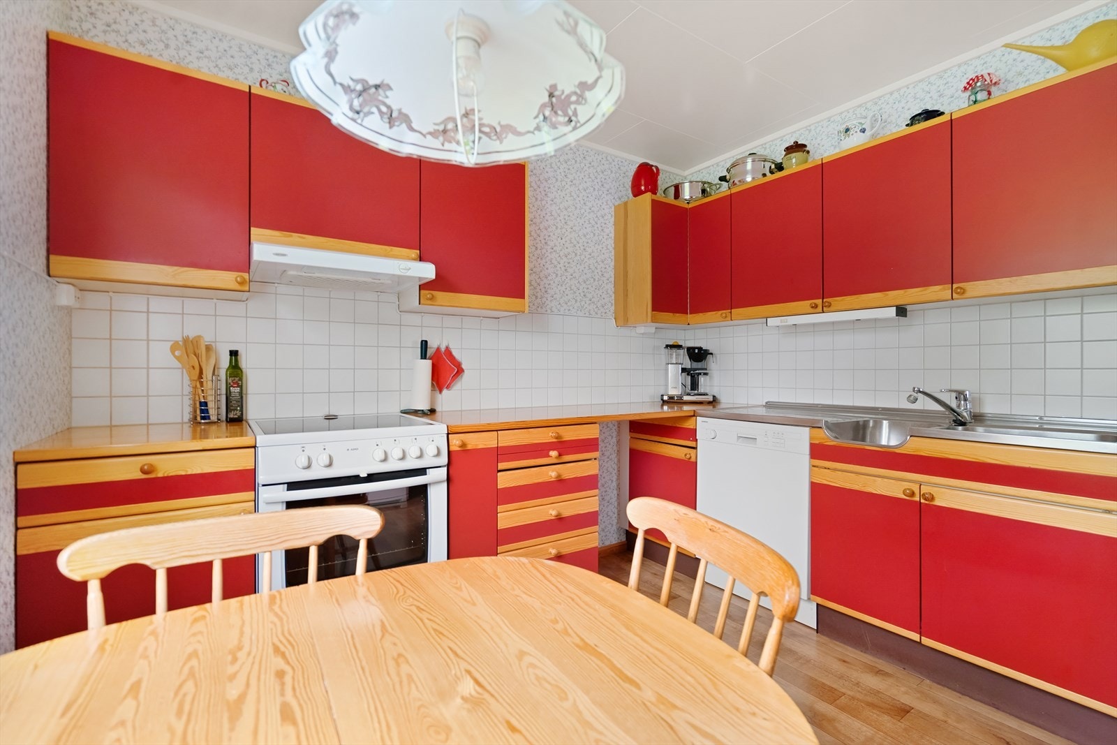 Fliser på vegg over benk og ventilator i overskap. Plass for komfyr, oppvaskmaskin og kjøleskap. Galleribilde