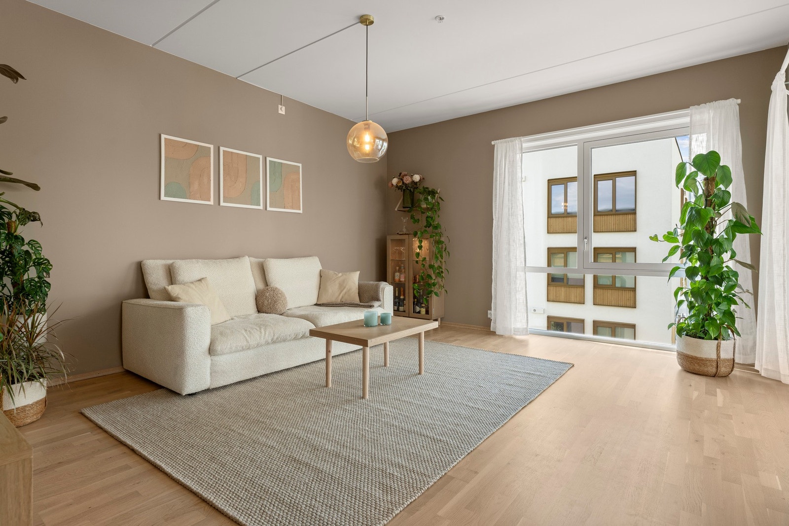 Store vindusflater gir naturlig lys, og overflater i parkett og malte flater gir en moderne stil. Galleribilde