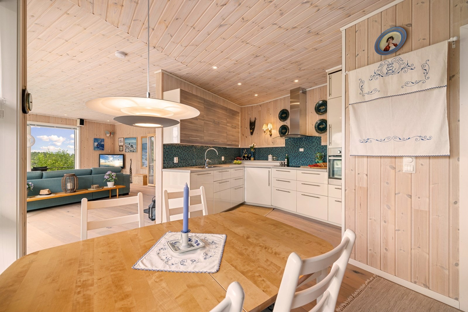 Lyst kjøkken med laminat benkeplater, nedfelt stål vaskebeslag og platetopp. Galleribilde