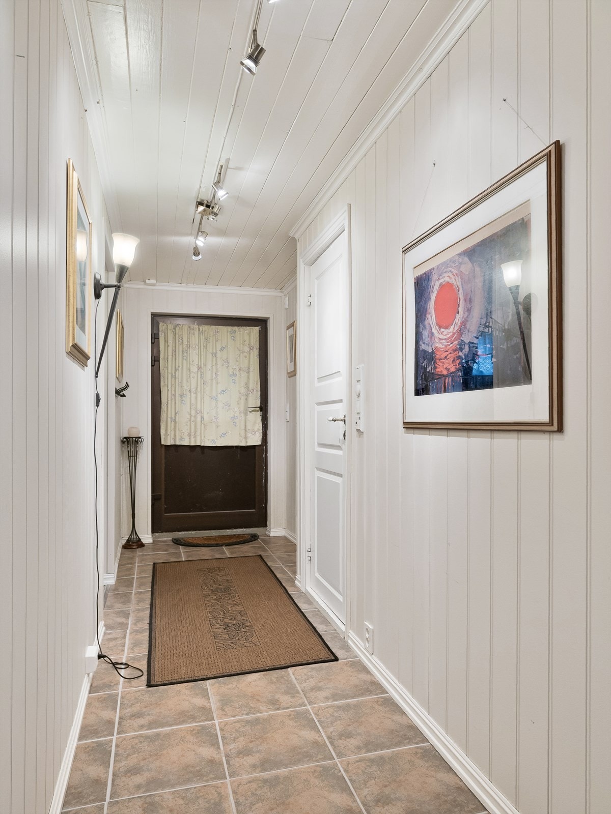 Gang nede i underetasjen, med flislagt gulv og varmekabler. Her er det også bi-inngang fra utsiden. Galleribilde