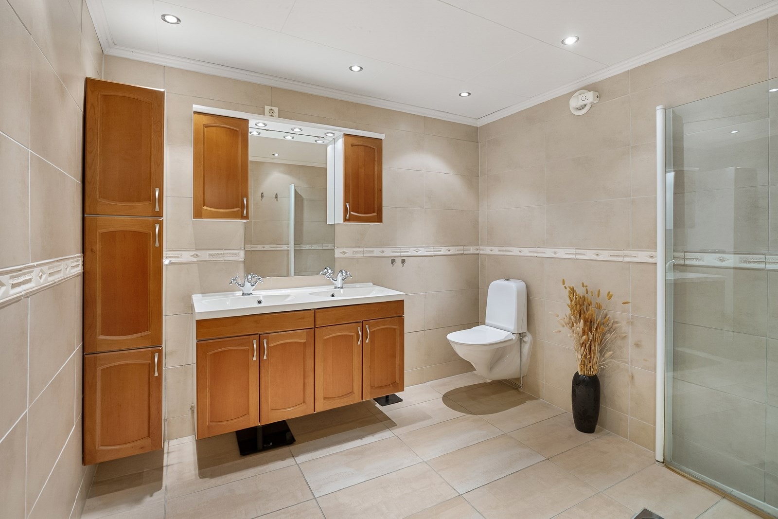 Flott bad med fliser på gulv og vegg. Gulvet har varmekabler. Galleribilde