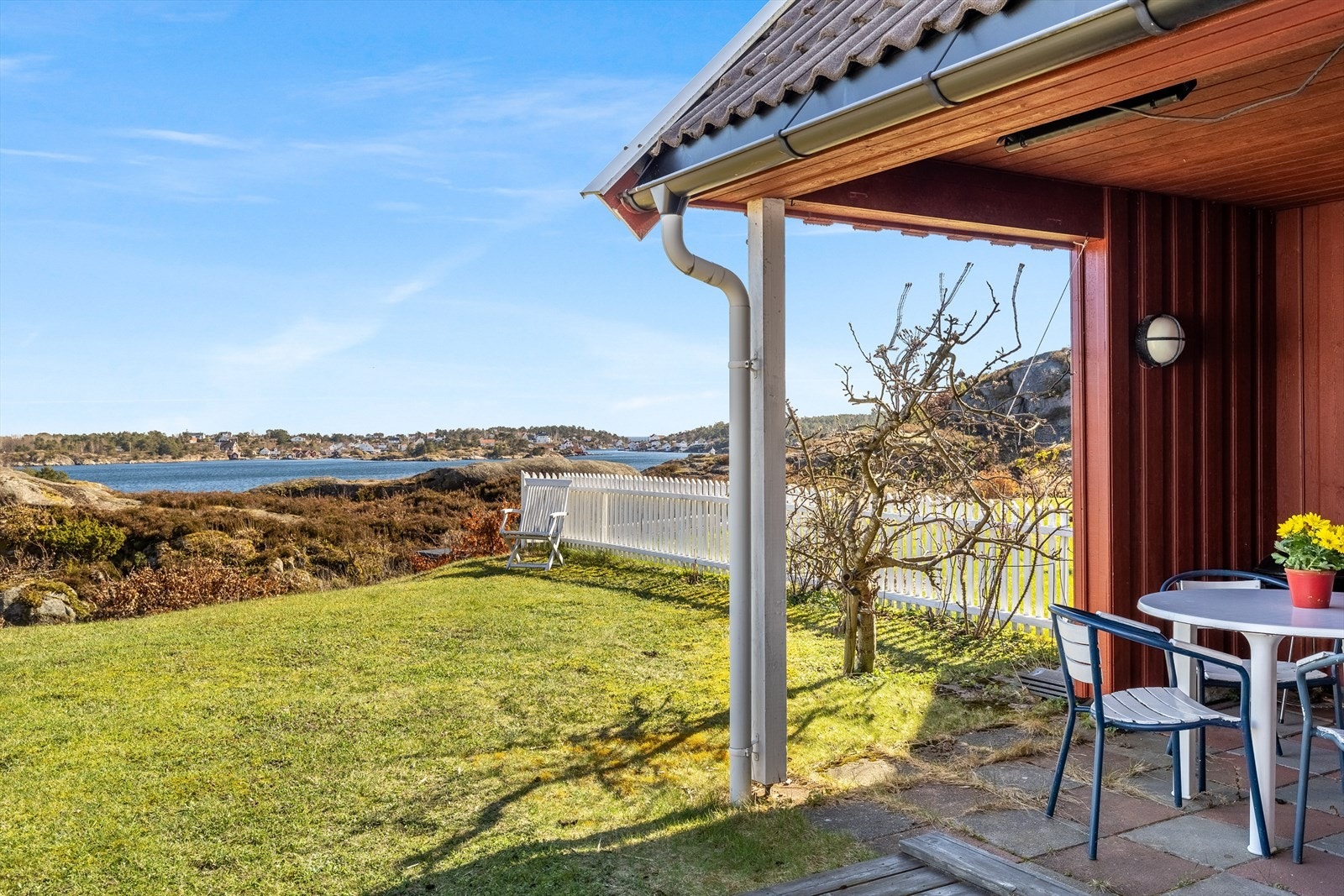 Hyggelig hage med plen, terrasse og overbygd tak i tilknytning til boden - hyggelig liten sone med plass til sittegruppe Galleribilde