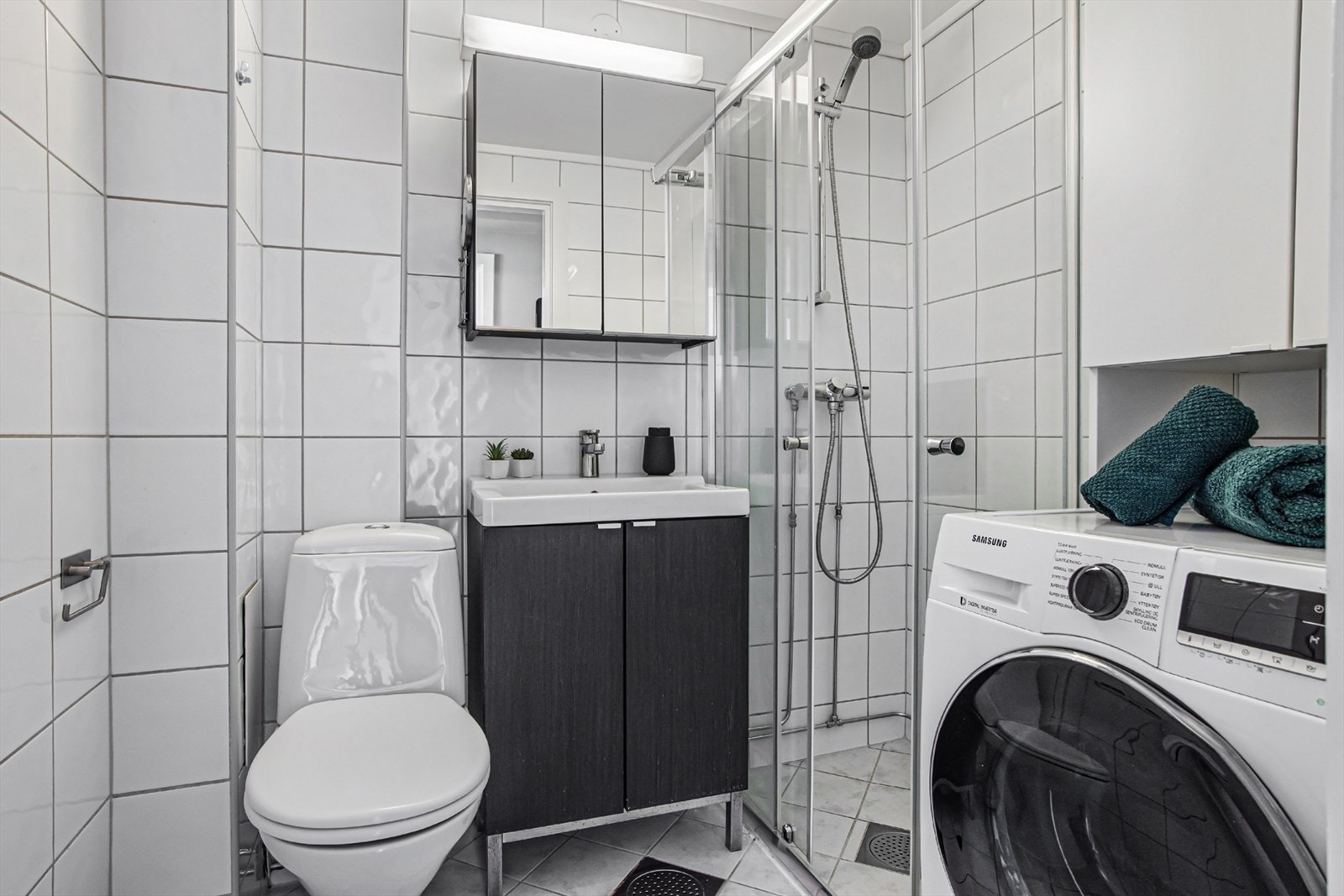 Flislagt bad med dusjnisje og gulvstående toalett. Galleribilde