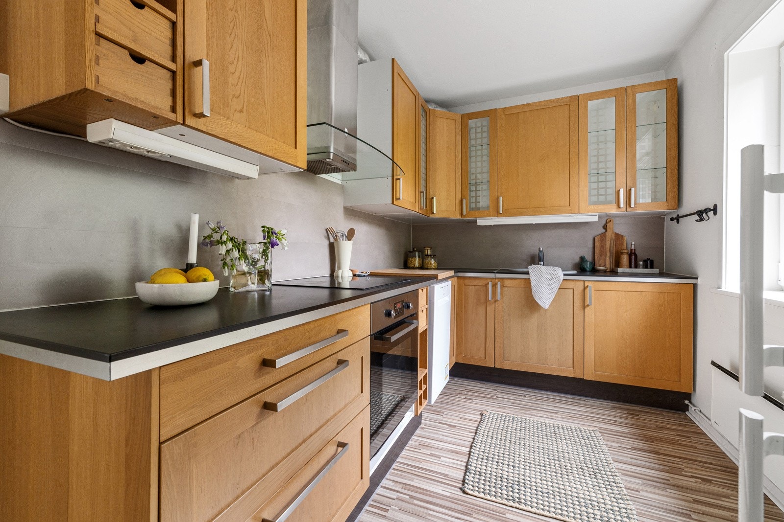 Kjøkkenet er innredet med profilerte fronter fra IKEA og har moderne løsninger som soft close-skuffer, fliser over benk og stilren armatur. Galleribilde