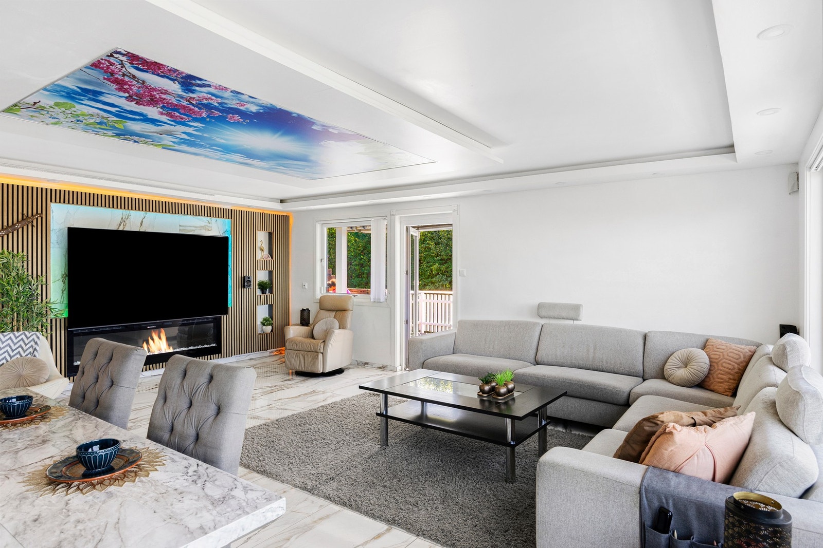 Elegant TV-vegg med moderne spilepanel som omrammes av diskret LED-belysning. Galleribilde