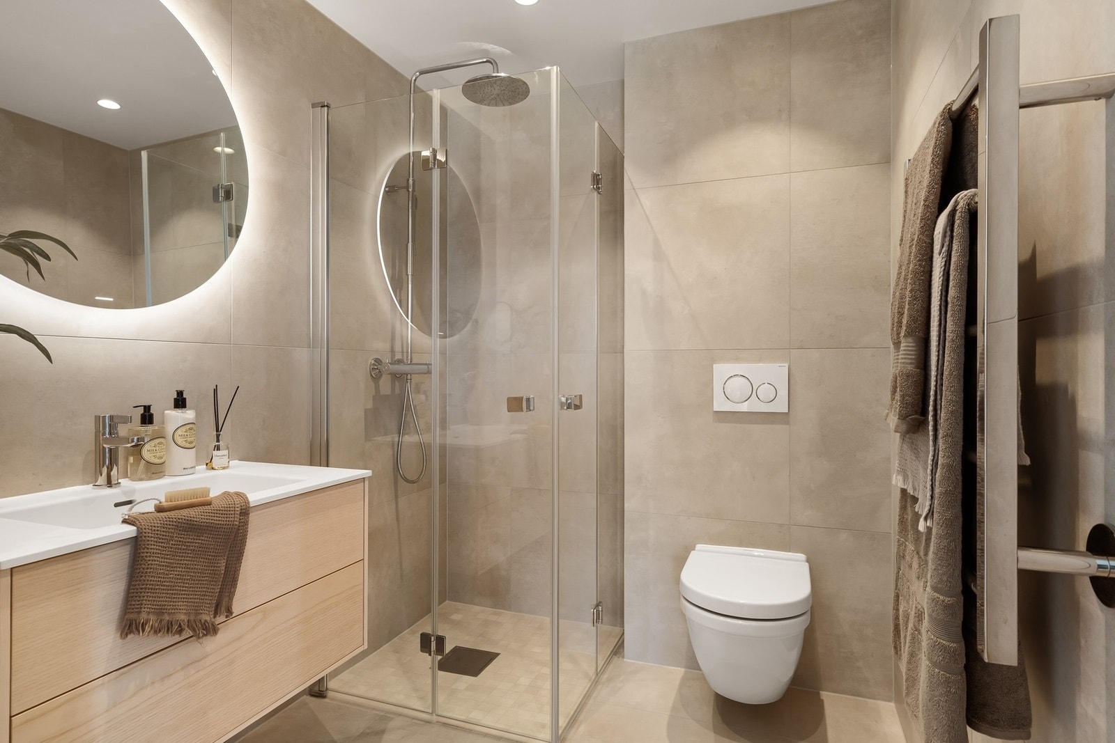 Badet tilhørende hovedsoverommet. Beige fliser på gulv og vegger, samt varmekabler Galleribilde