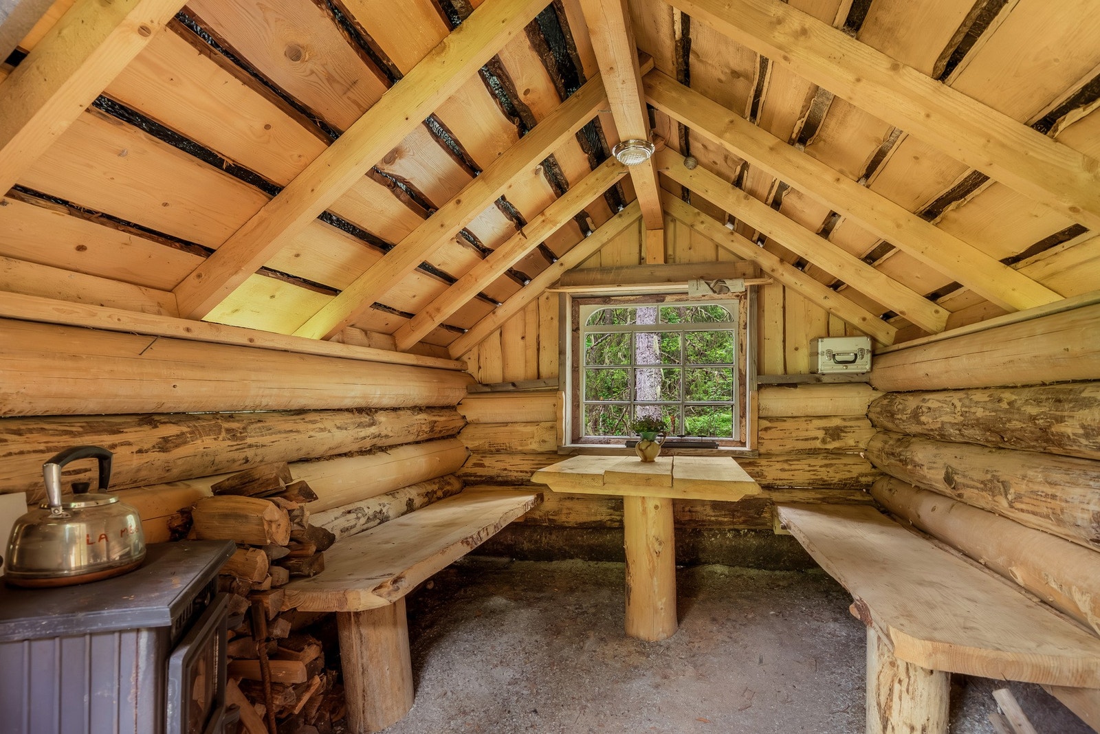 Innredet med sitteplasser og en vedovn. Galleribilde