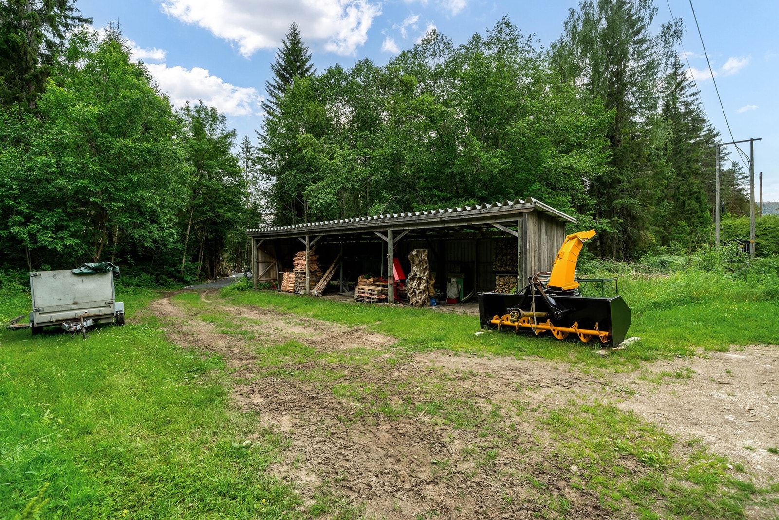 Det er også ett stolpeskur, med god plass til oppbevaring av for eksempel ved, eller redskaper. Galleribilde
