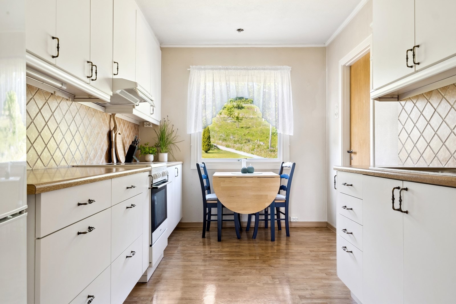 Kjøkken med takhøy innredning og egen spiseplass Galleribilde