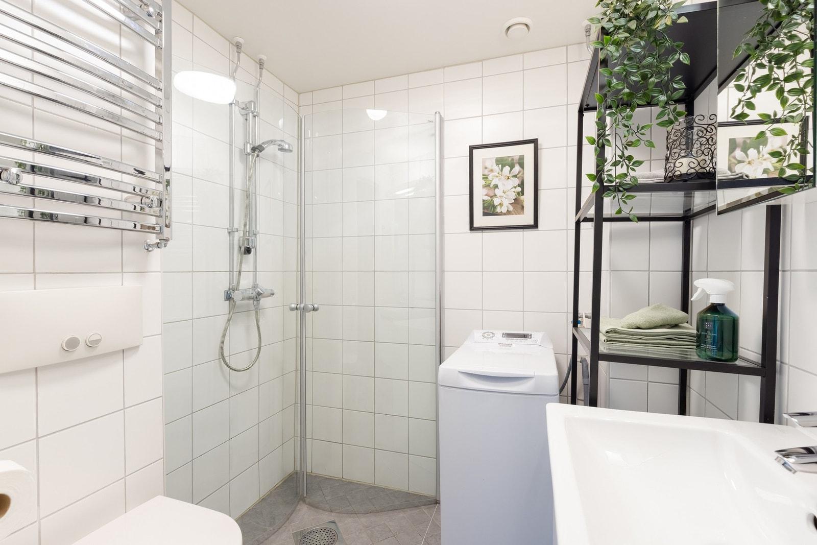 Det flotte, flislagte baderommet ligger i tilknytning til entréen. Videre er det dusjnisje, servant med skuffer og opplegg for vaskemaskin. Galleribilde