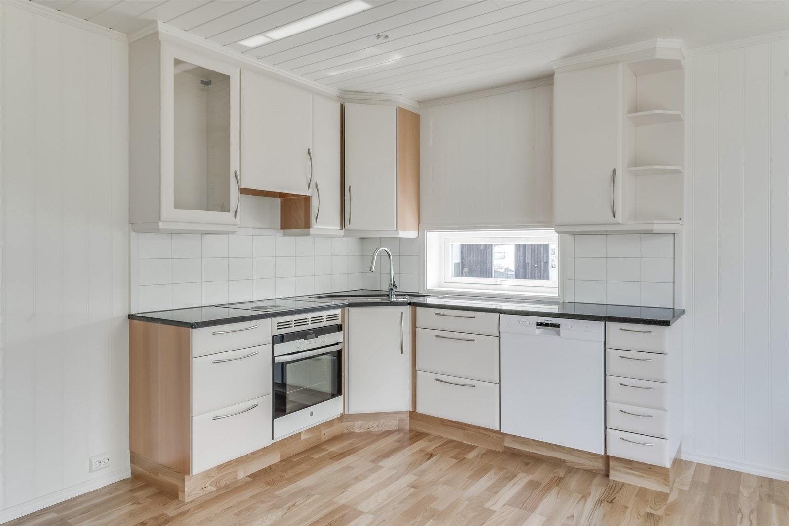 Kjøkkeninnredning i over- og underskap, samt en benkeplate av stein. Galleribilde