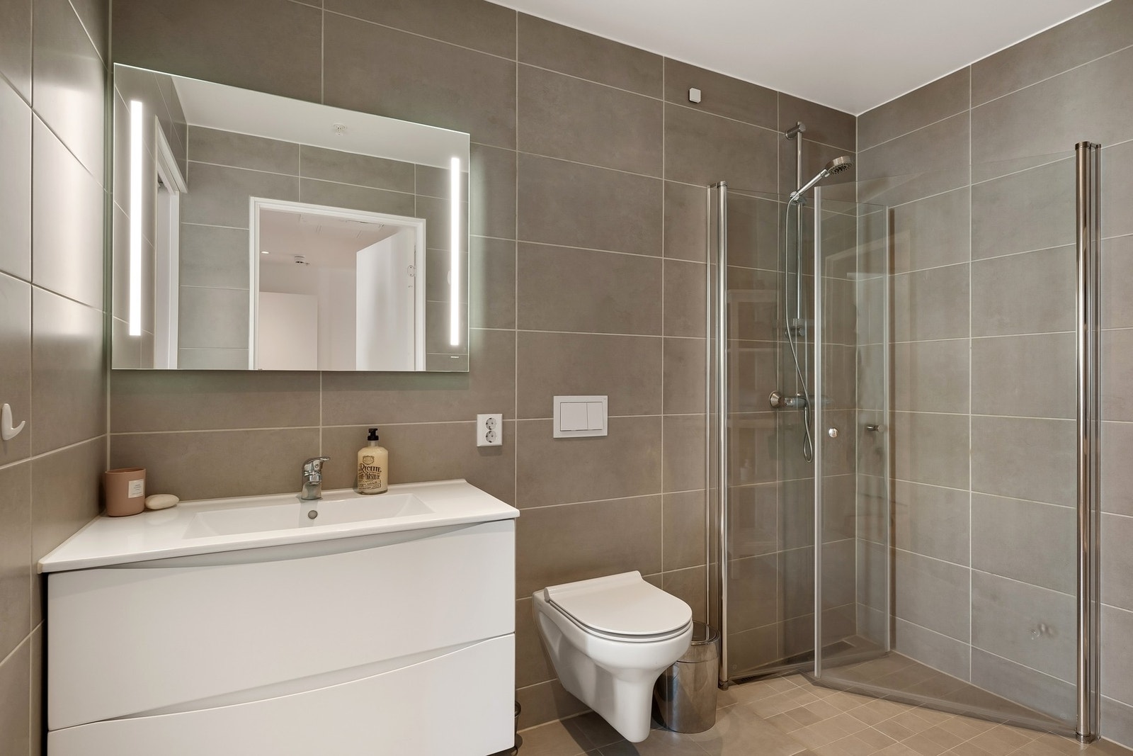 Lekkert og moderne bad med en gjennomført stil med varmekabler i gulv Galleribilde