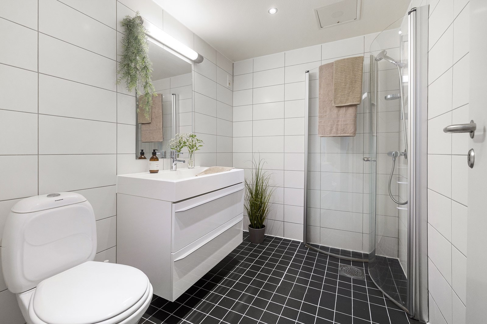 Romslig og tidløst bad av god størrelse. Badet har flislagte overflater, behagelig gulvvarme og downlights i himling. Galleribilde